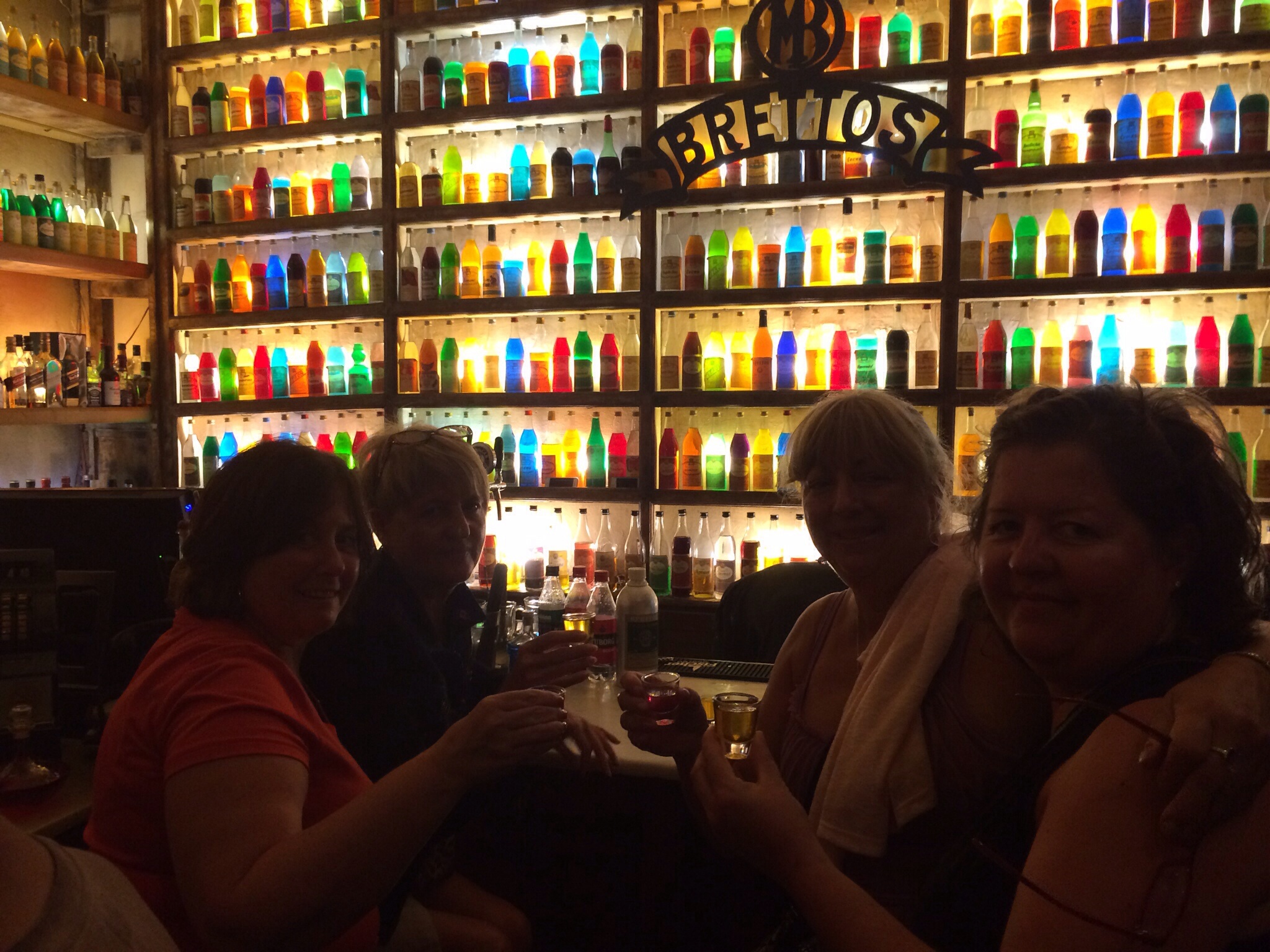 colourful bottles of ouzo lined up and filling a wall
