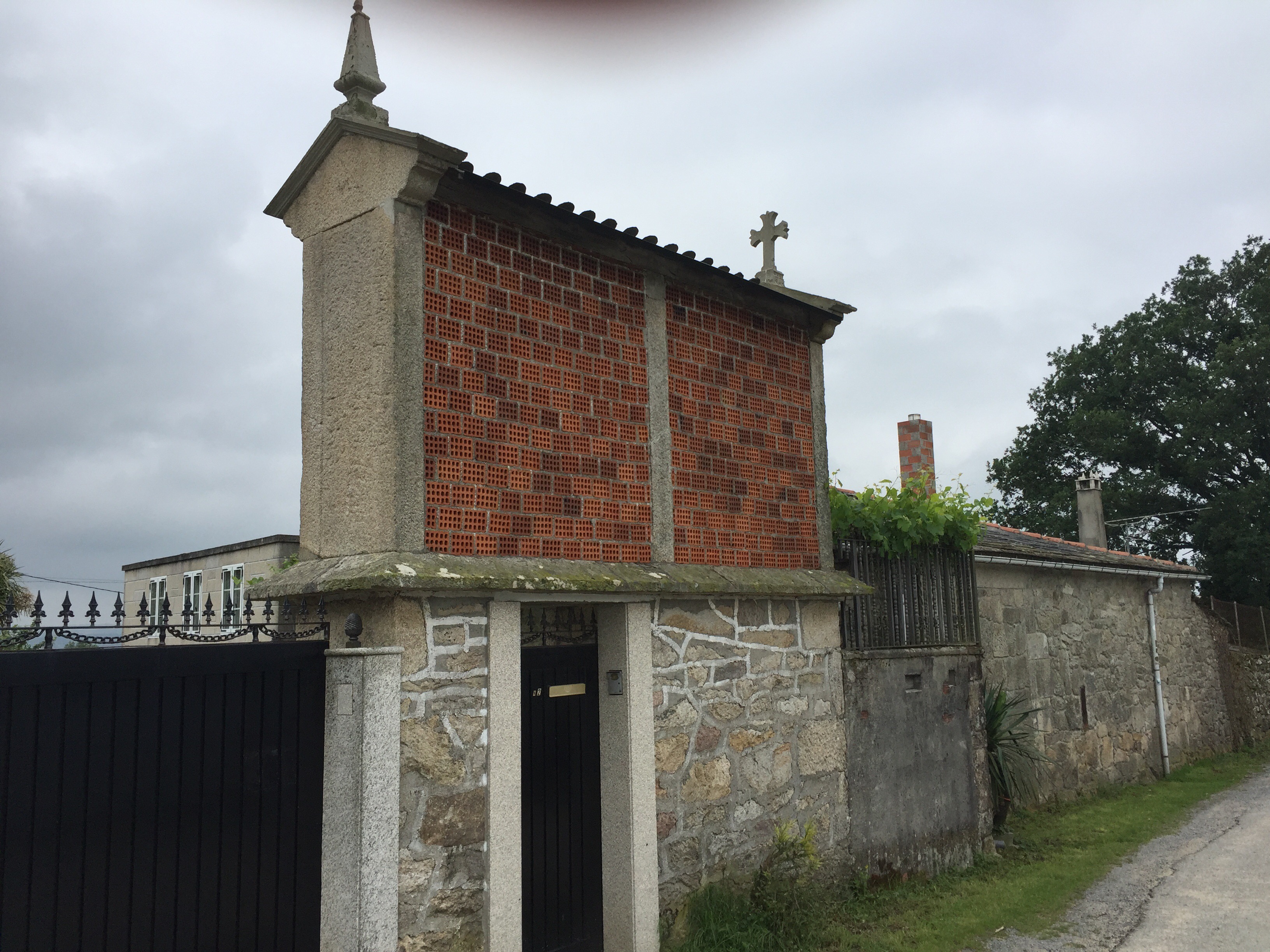 Brick structure sits on top of stone fence to store corn.